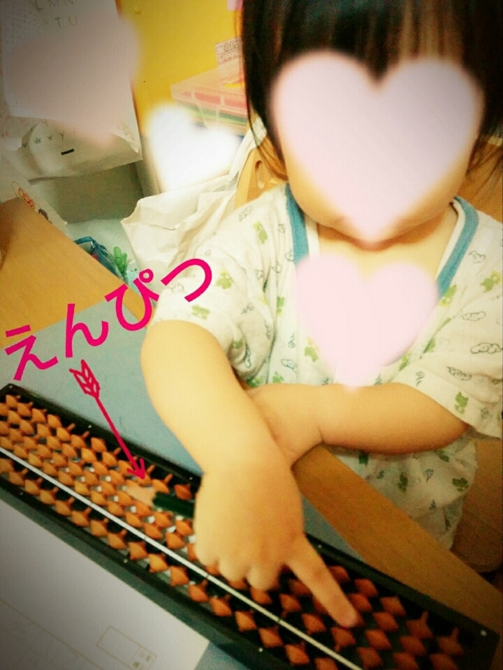 そろばんの真似をする1歳児